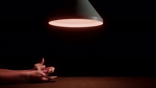 Money Exchange Takes Place Under a Dim Lamp