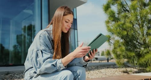 Woman Uses Tablet Device Outside Modern Building