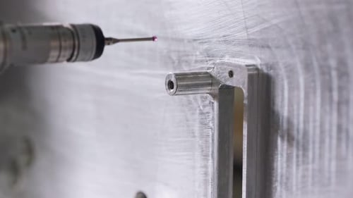 Macroscopie d'une machine à mesurer tridimensionnelle (CMM) mesurant une pièce métallique