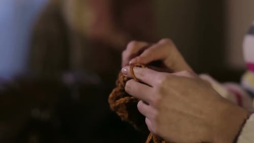 Hands Knitting Brown Yarn in Detailed Close Up