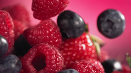 Fresh Mixed Berries Falling in Slow Motion with Pink Background