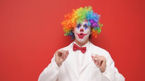 Expressive Clown With Multicolored Wig Against Red Backdrop