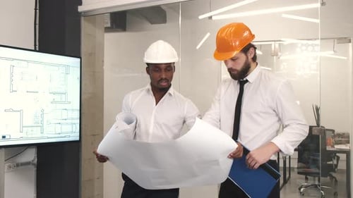 Architect and Engineer Looking at Scketch Blueprint at Office and Discussing Project