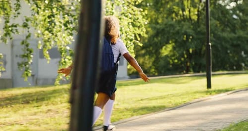 Schoolgirl with a Backpack Runs to School