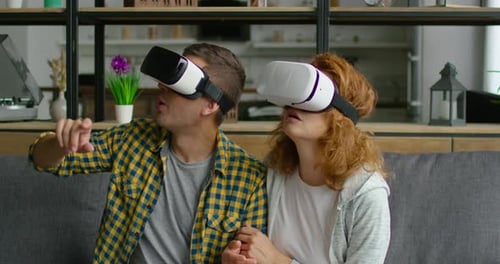 Enthusiastic Couple Experiencing Virtual Reality on Couch