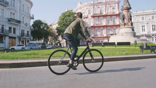 Cyclist Man Riding Fixed Gear Sport Bike in Sunny Day on a City