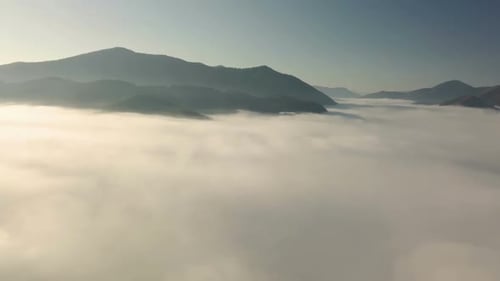 Aerial Flight into the Clouds in Morning Mountains Landscape