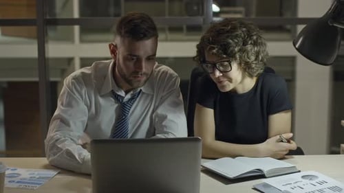 Coworkers Discussing Project in Night Office