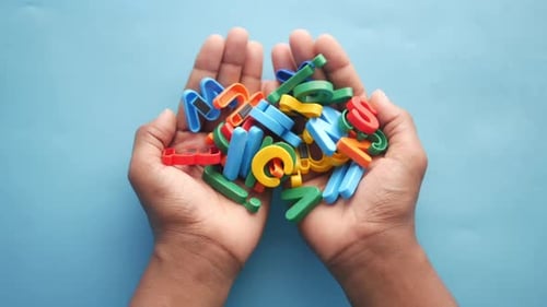 Hands Holding Colorful Plastic Alphabet Letters Overhead