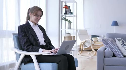 Successful Young Woman Working on Laptop in Living Room