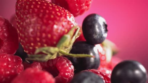 Fresh Mixed Berries Falling in Slow Motion with Pink Background