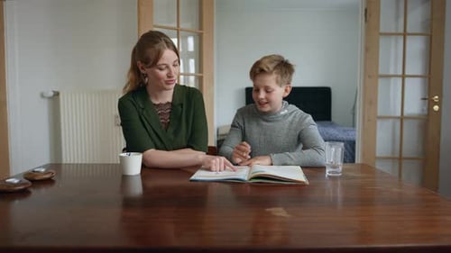 Woman Helping Child With Homework At Home