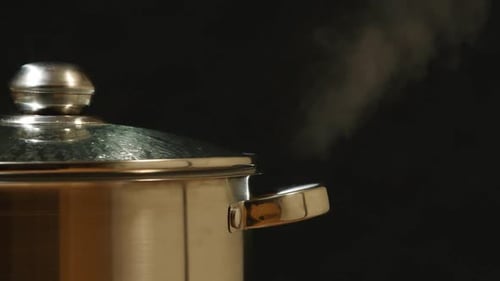 Stream Breaks Out Of A Steel Pan On A Black Background