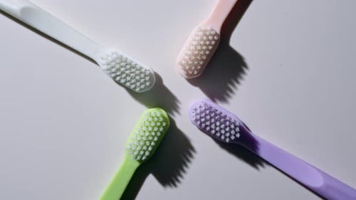 Colorful Toothbrushes Rotating on White Surface