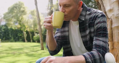 Man Drinking Coffee and Relaxing in Garden