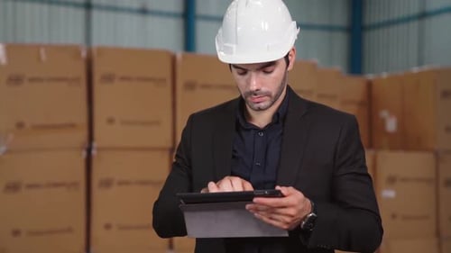 Factory Manager Using Tablet Computer in Warehouse or Factory