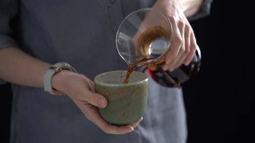 Woman Pouring Coffee into Mug, Close Up Shot
