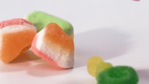 Colorful Gummy Candies Falling on White Surface