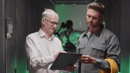 Ingenieur spricht mit Elektriker im Serverraum