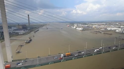 Aerial Chase of Traffic Across A Suspension Bridge