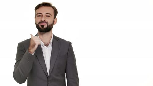 Man in Suit Smiles, Points, and Gives Thumbs-Up