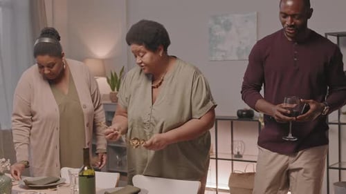 Adults Setting Up Dining Table for Family Meal