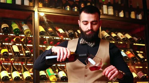 Bearded Adult Pours and Examines Red Wine