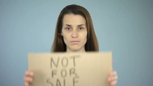 Panneau interdit à vendre entre les mains d'une femme, esclavage sexuel, traite d'êtres humains, voies de fait