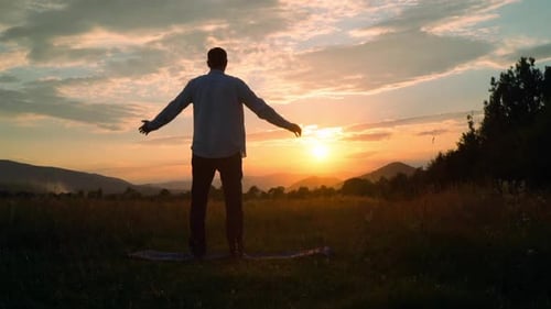 Man Meditating at Sunrise in Rural Field