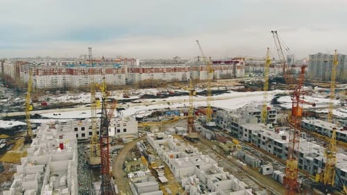 Sitio de construcción: grúas amarillas de un edificio en progreso