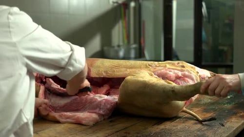 Butchers Cutting Pig Carcass in Commercial Kitchen