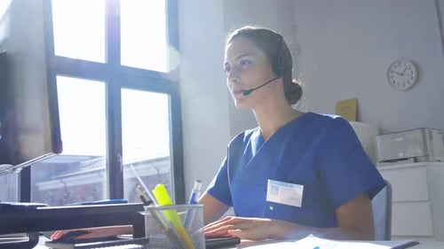 Doctor with Headset and Computer at Hospital