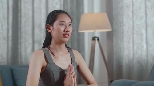 Young Asian Athletic Female Exercising, Stretching And Practising Yoga On The Mat At Home
