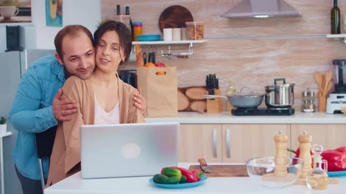 Woman Using Laptop in Kitchen