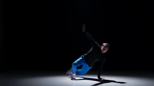 Un jeune danseur continue à danser le breakdance, noir