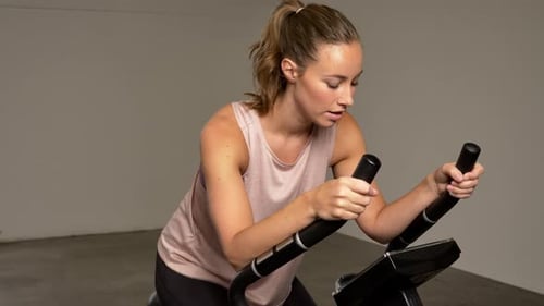 Woman Exercising on Stationary Bike Indoors