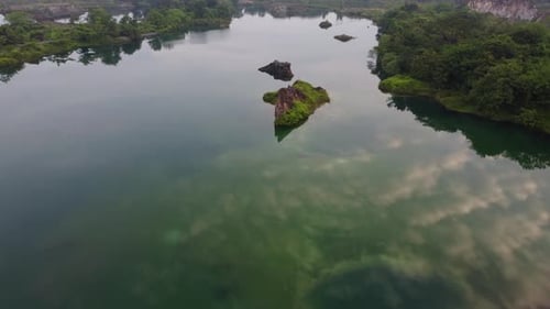 Luftflug über Steinbruchbecken mit klarer Wasserreflexion