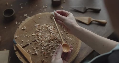 Woman Carpenter Varnishes Wooden Spoon with Oil Close-up