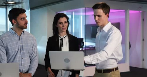 Diverse Team Collaborates on Laptop in Modern Office