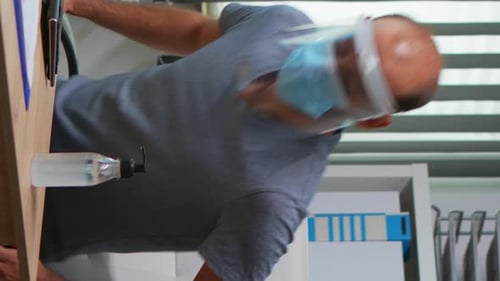Man Sanitizes Hands and Uses Tablet in Office