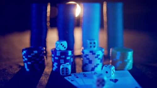 Casino Chips with Dice and Playing Cards on a Dark Table