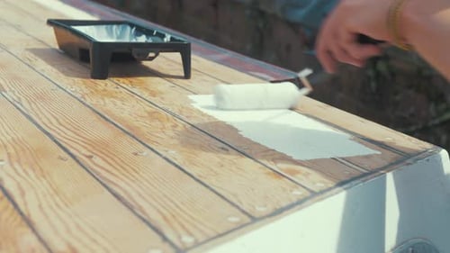 Applying White Paint to Wooden Boards With Roller