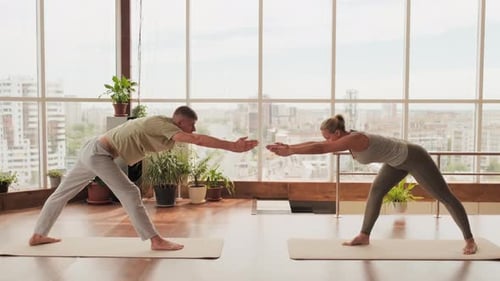 Couple Doing Forward Bends Practicing Yoga