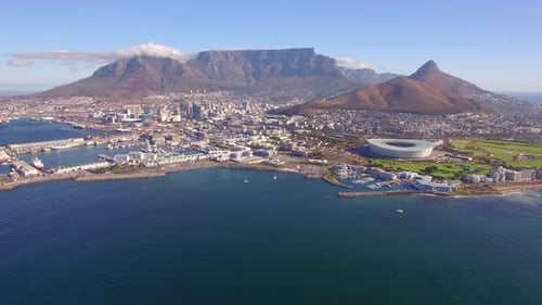 Aerial travel drone view of Cape Town, South Africa with Table Mountain and stadium.