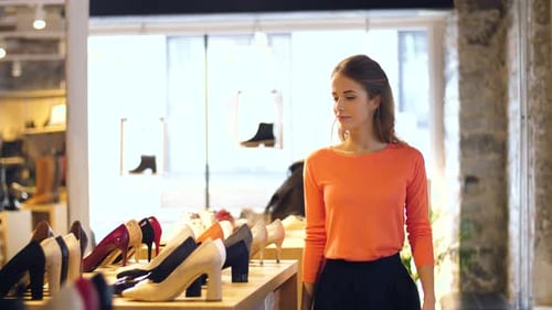 Happy Young Woman Choosing Shoes at Store