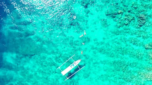 Wide fly over travel shot of a sandy white paradise beach and blue sea background in hi res 4K