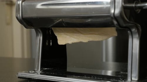 Pasta Dough Being Run Through Machine
