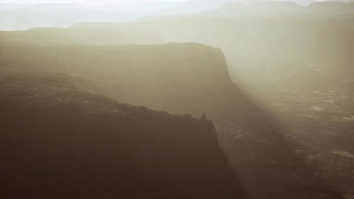 Aerial View of Foggy Mountain Canyon with Sunbeams