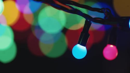 Close-up of New Years Bulb of Garland on Background of Bokeh Flickering Lights. Christmas Blurred