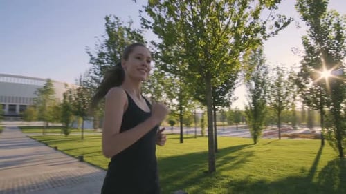 Sports Woman Makes Morning Jog and Physical Exercises In Park